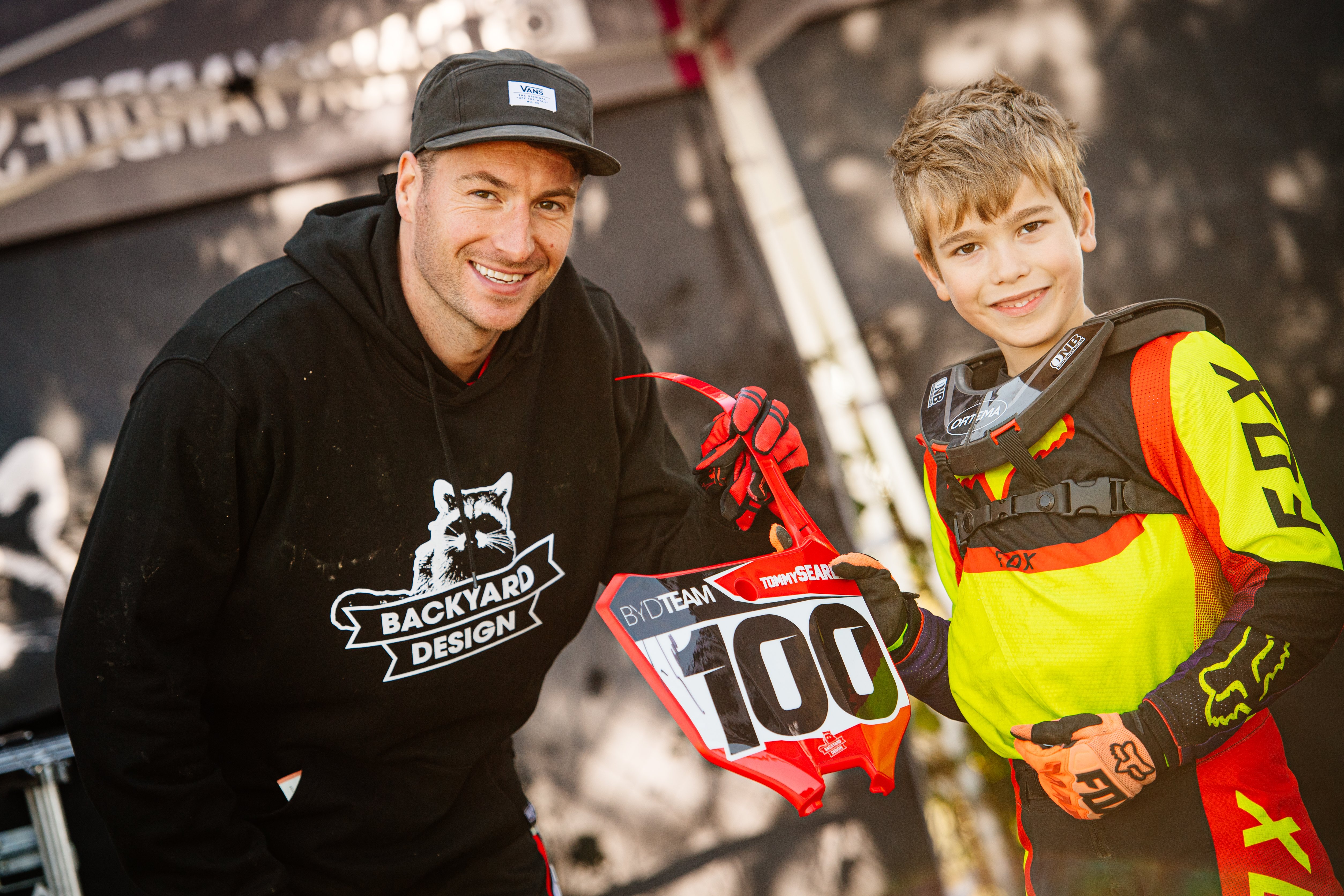Pro rider Tommy Searle gifting a signed front plate to a young rider